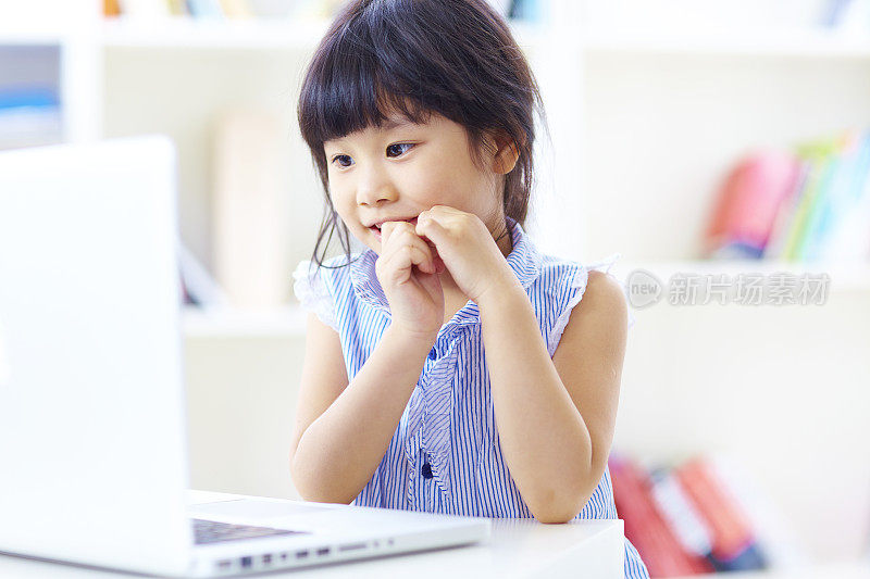 lovely little girl using laptop in home重复图片